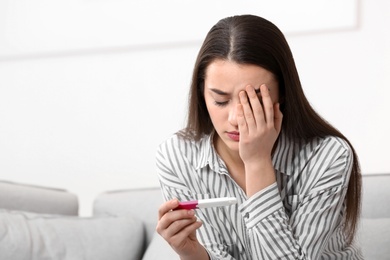 Photo of Young woman with pregnancy test at home. Gynecology and childbirth