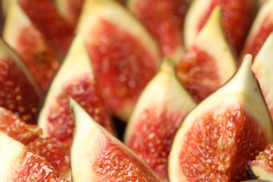 Photo of Slices of tasty fresh figs as background, closeup