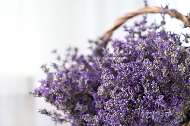 Photo of Fresh lavender flowers in basket on blurred background, closeup. Space for text
