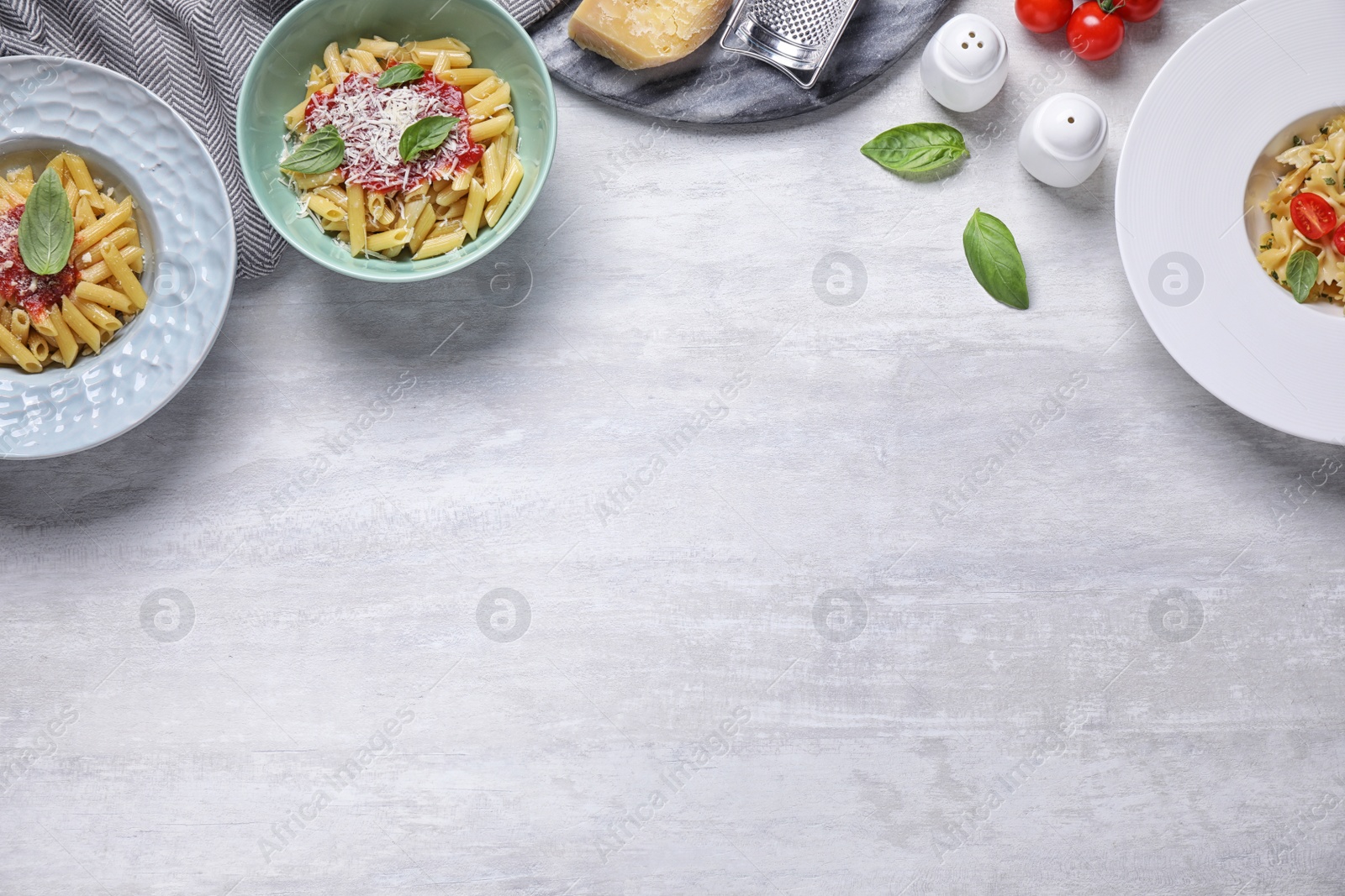 Photo of Delicious pasta with tomato sauce served on white table, flat lay. Space for text