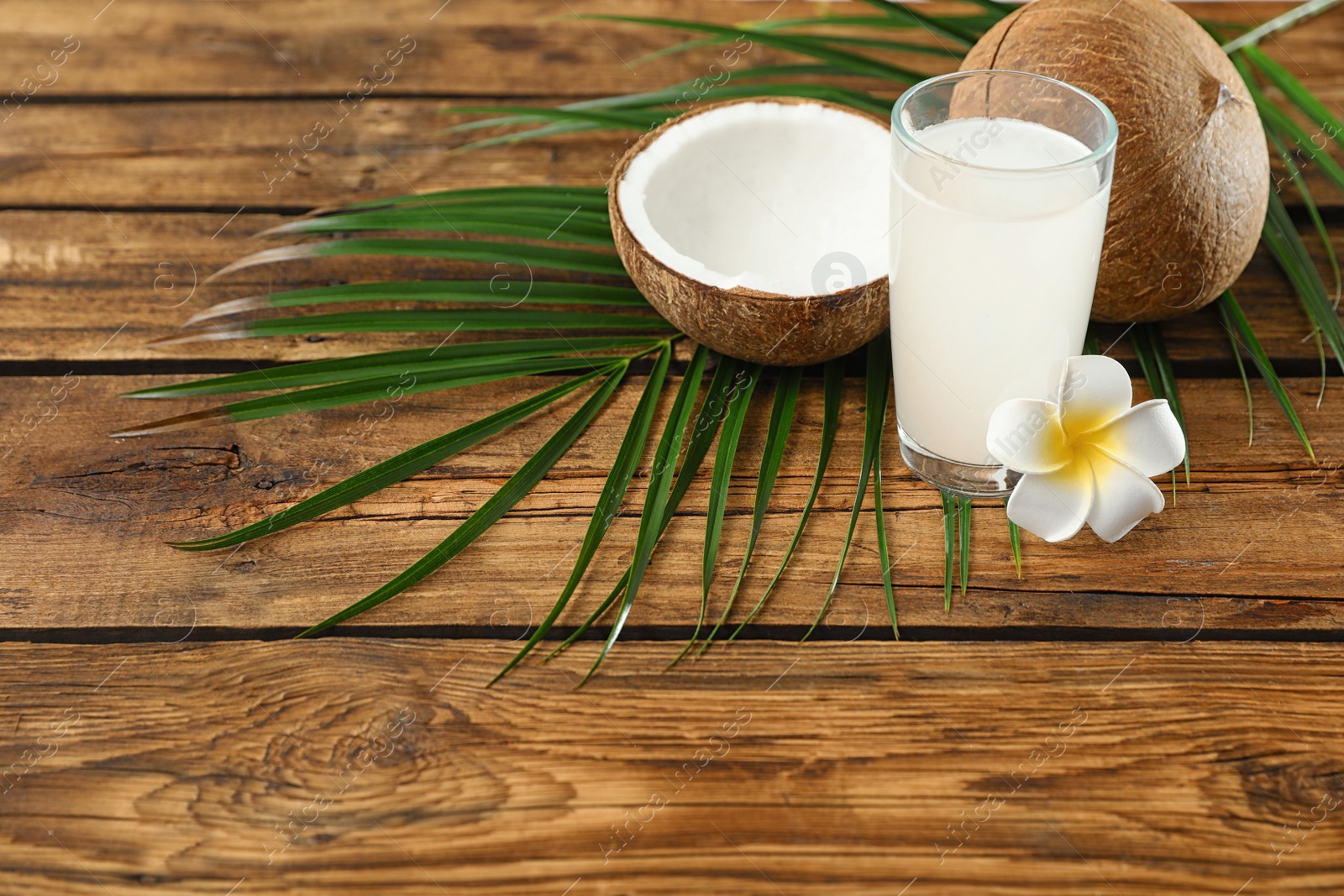 Photo of Composition with glass of coconut water on wooden background. Space for text