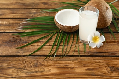 Photo of Composition with glass of coconut water on wooden background. Space for text
