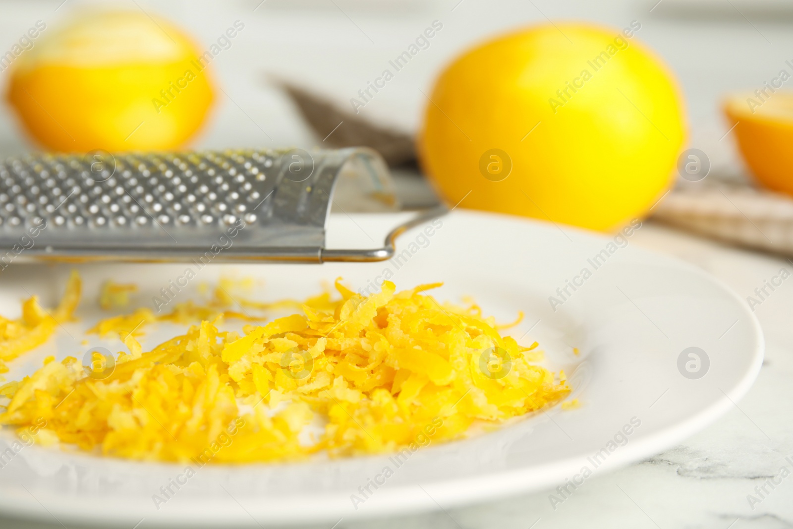 Photo of Fresh lemon zest on plate, closeup view