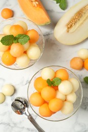 Flat lay composition with melon balls and mint on white marble table