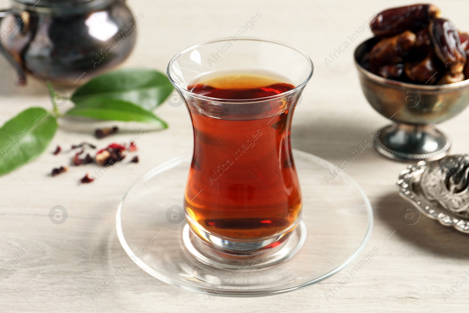 Photo of Tea in glass and vintage tea set on wooden table