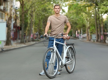 Photo of Handsome man with bicycle outdoors on summer day