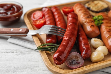 Photo of Delicious grilled sausages on white wooden table, closeup. Barbecue food