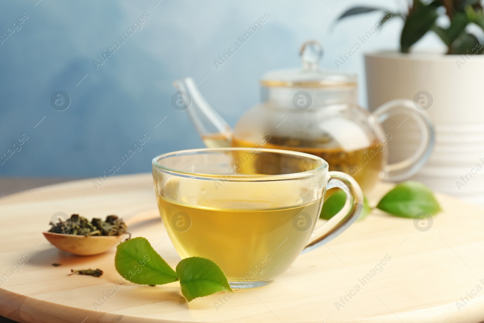 Photo of Cup of hot aromatic tea and teapot on table