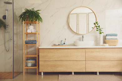 Photo of Stylish bathroom interior with countertop, mirror and shower stall. Design idea