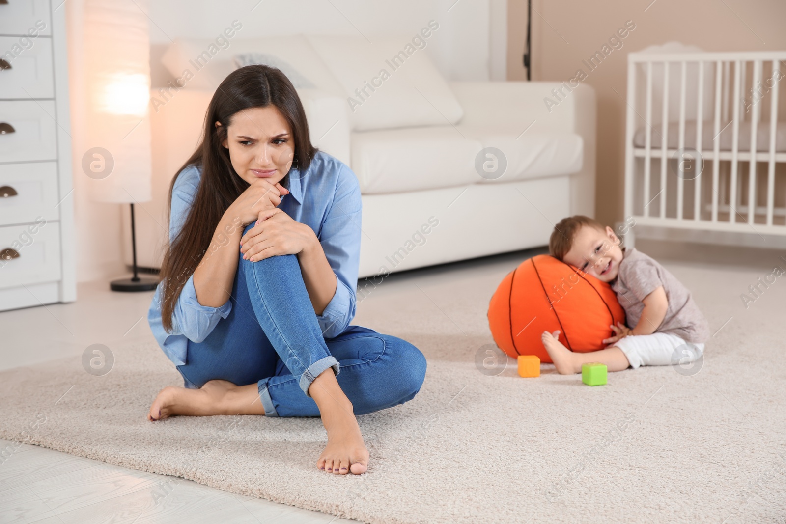 Photo of Young mother suffering from postnatal depression and cute baby boy at home