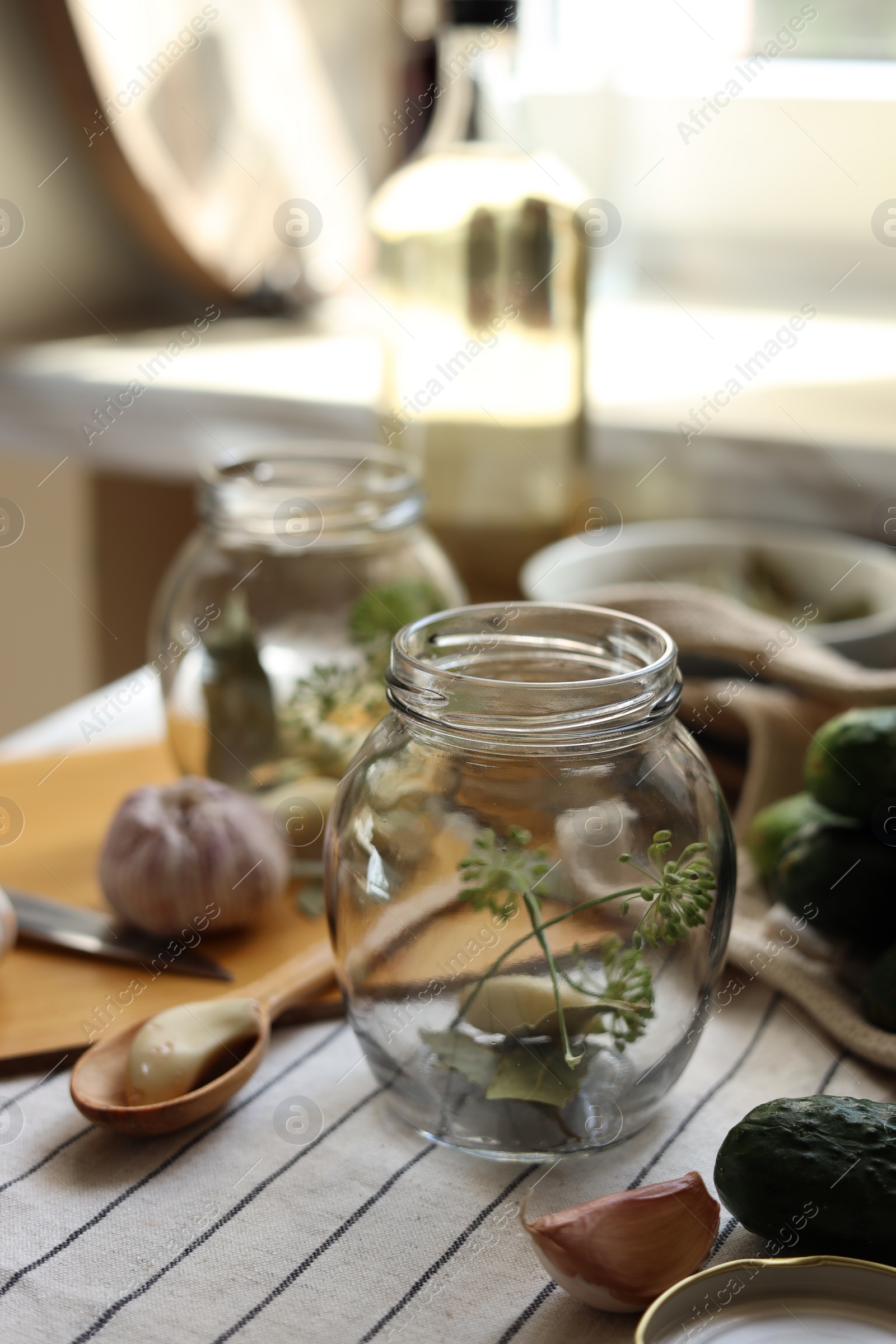 Photo of Empty glass jars and ingredients prepared for canning on table indoors