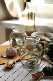 Photo of Empty glass jars and ingredients prepared for canning on table indoors