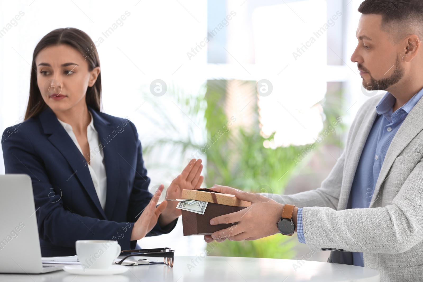 Photo of Businesswoman refusing to take bribe at table indoors