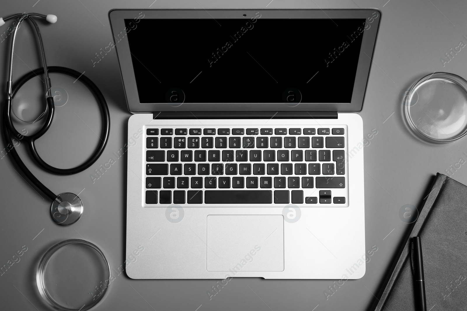 Photo of Modern laptop and medical students stuff on table, top view