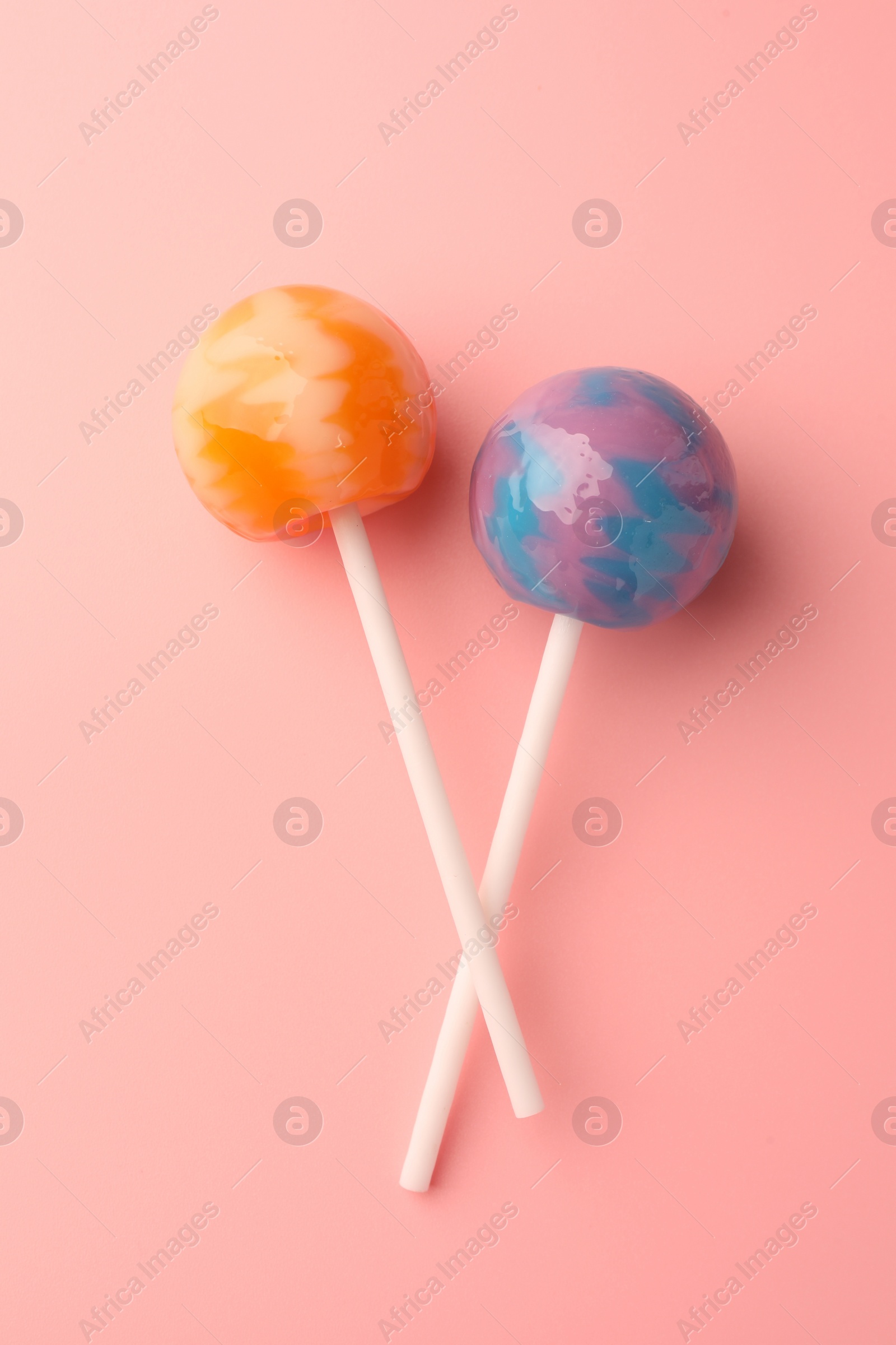 Photo of Tasty lollipops on pink background, flat lay