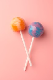 Photo of Tasty lollipops on pink background, flat lay