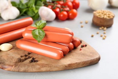 Photo of Fresh raw vegetarian sausages and vegetables on grey table, closeup