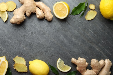 Frame of fresh lemons and ginger on grey table, flat lay. Space for text