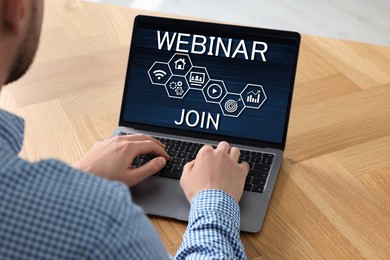 Online webinar, web page on computer screen. Man using laptop at wooden table, closeup