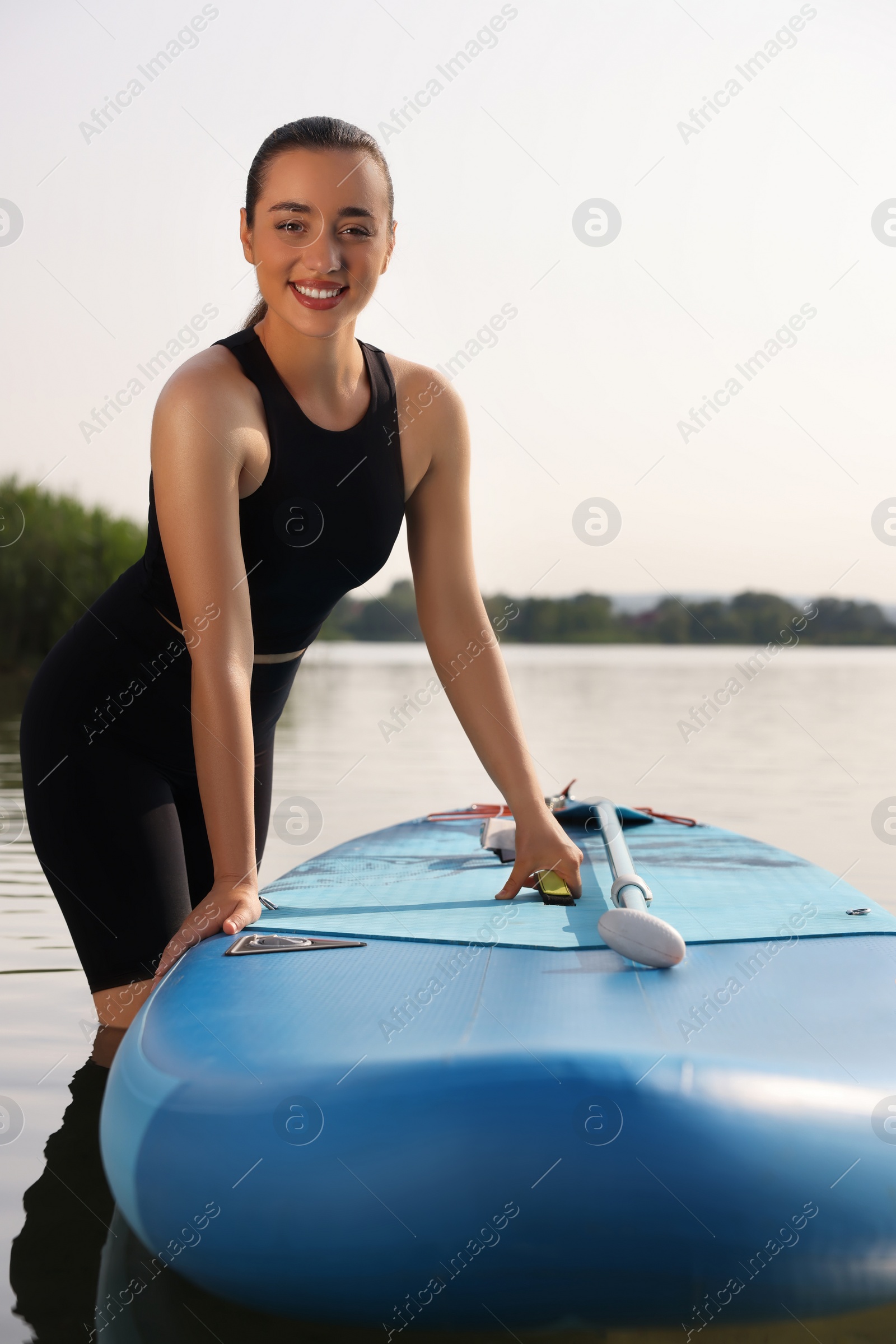 Photo of Woman standing near SUP board in water