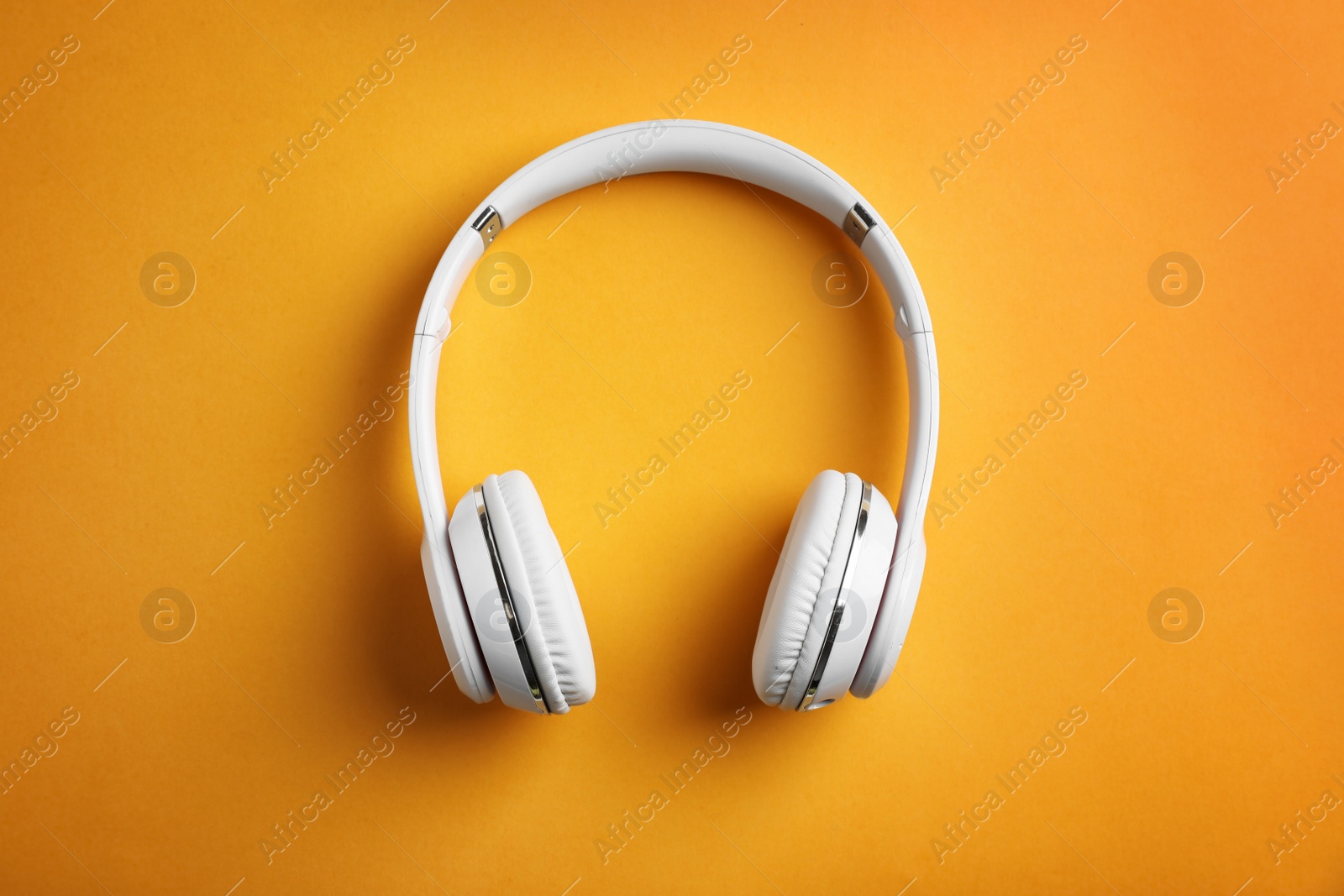 Photo of Wireless headphones on color background, top view