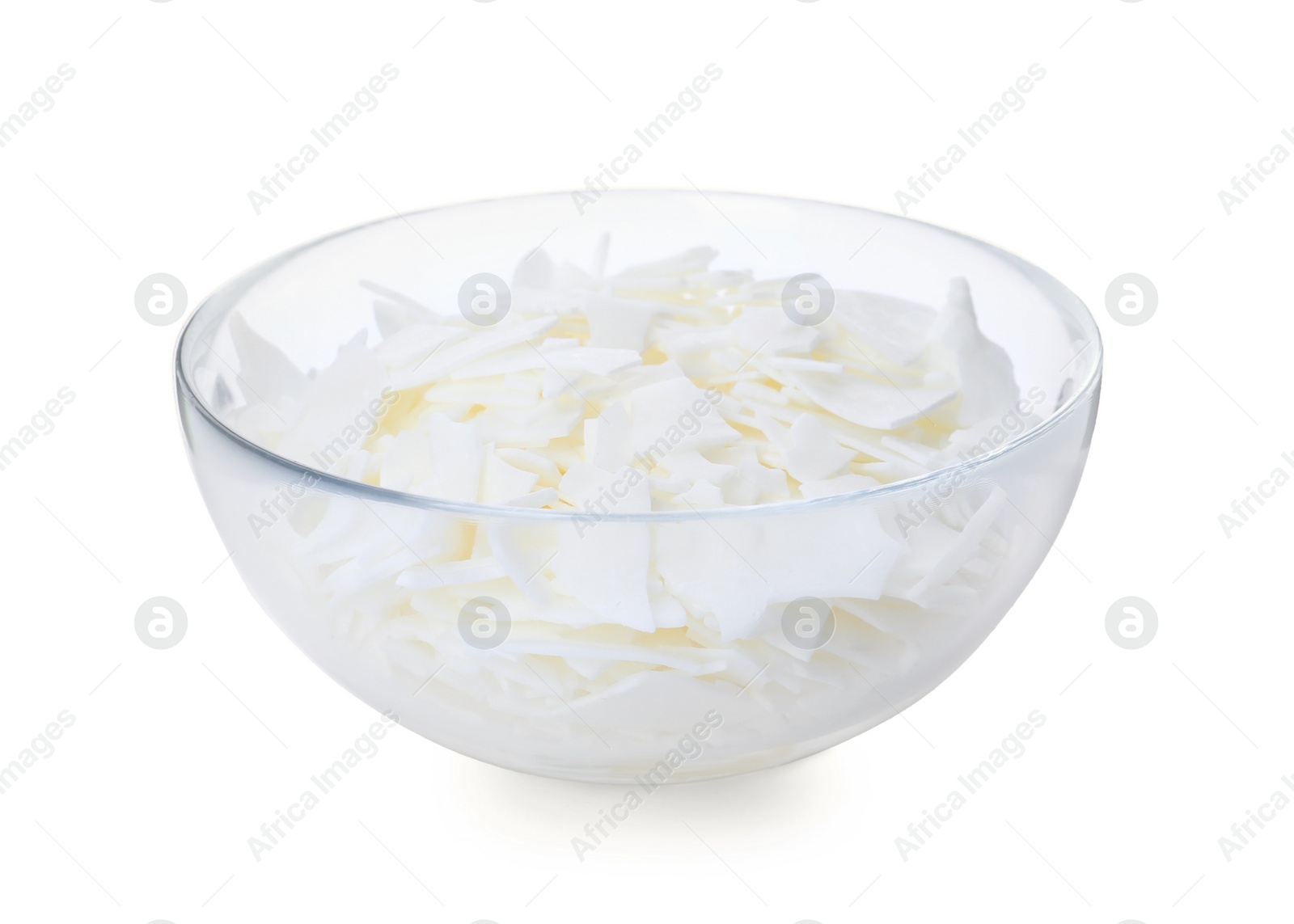 Photo of Wax flakes in glass bowl on white background. Homemade candle material