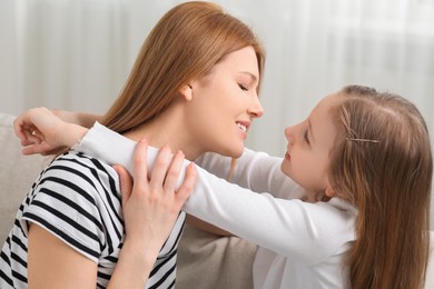 Portrait of mother and her cute daughter at home