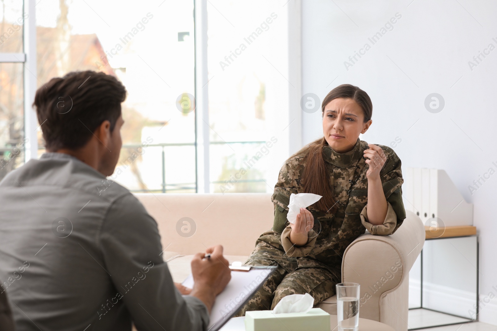 Photo of Psychotherapist working with female military officer in office
