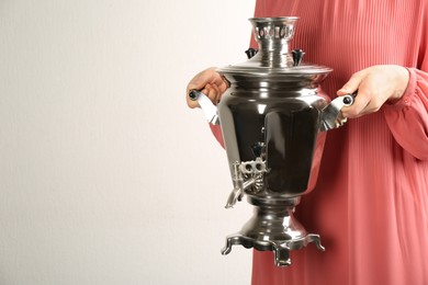 Woman holding traditional Russian samovar on white background, closeup. Space for text