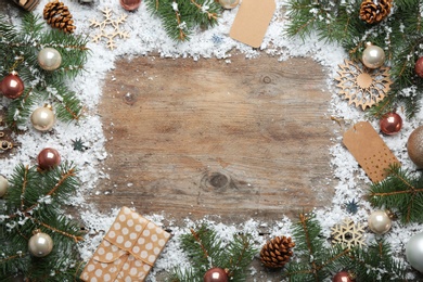 Photo of Frame made of Christmas decorations on wooden background, top view with space for text. Winter season