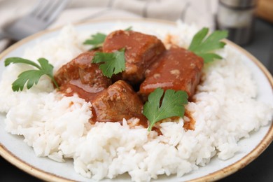 Delicious goulash served with rice on table, closeup