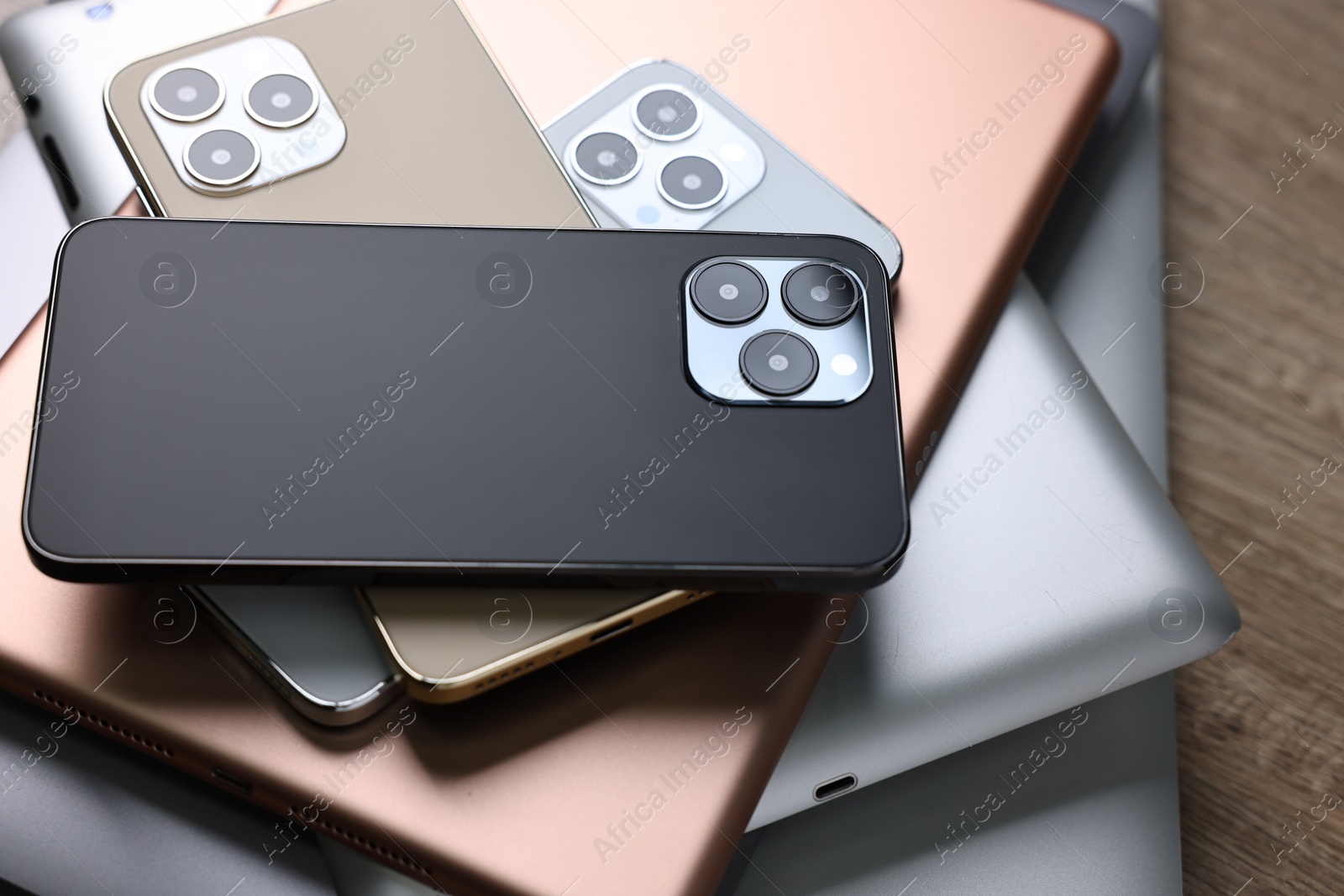 Photo of Many different modern gadgets on wooden table, closeup