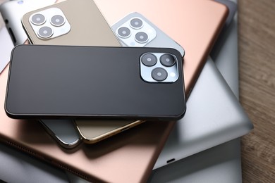 Photo of Many different modern gadgets on wooden table, closeup