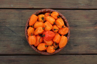 Ripe orange bell peppers on wooden table, top view