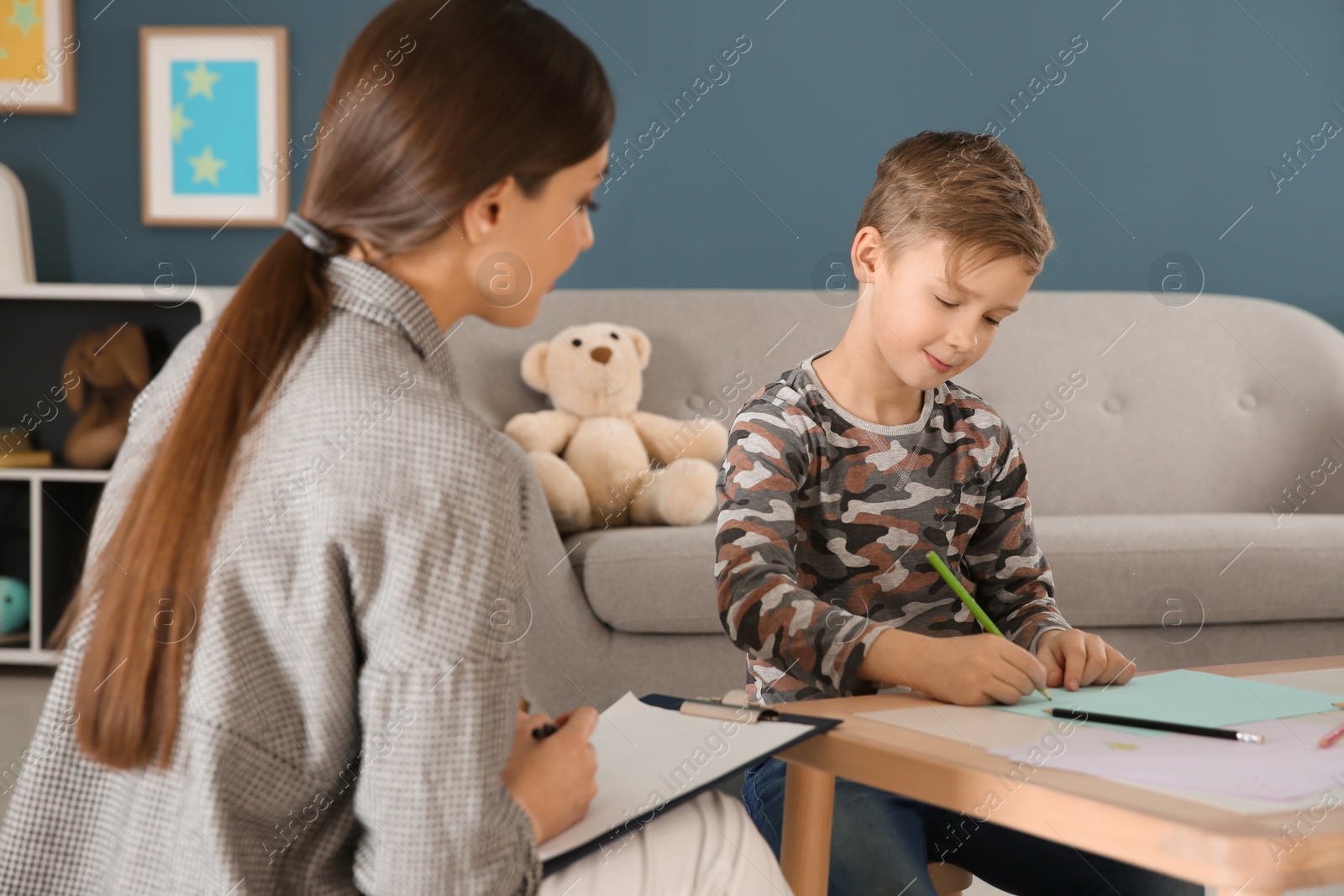 Photo of Female psychologist working with cute little boy in office
