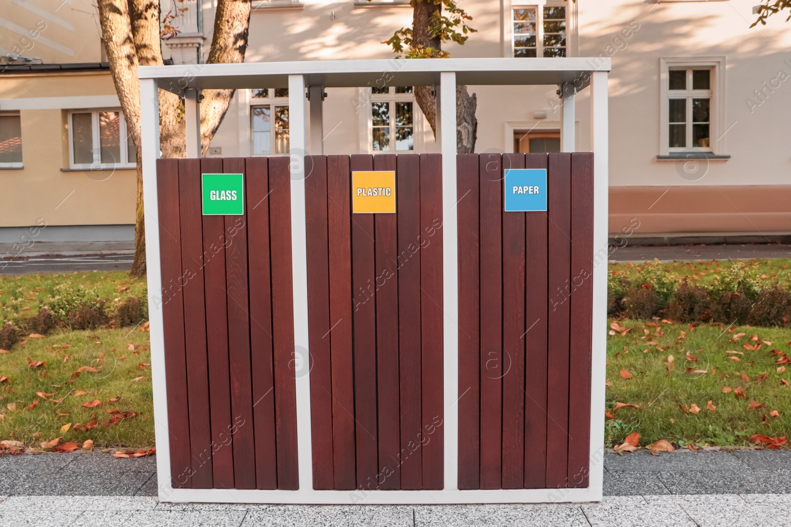 Photo of Different sorting bins for waste recycling on city street outdoors