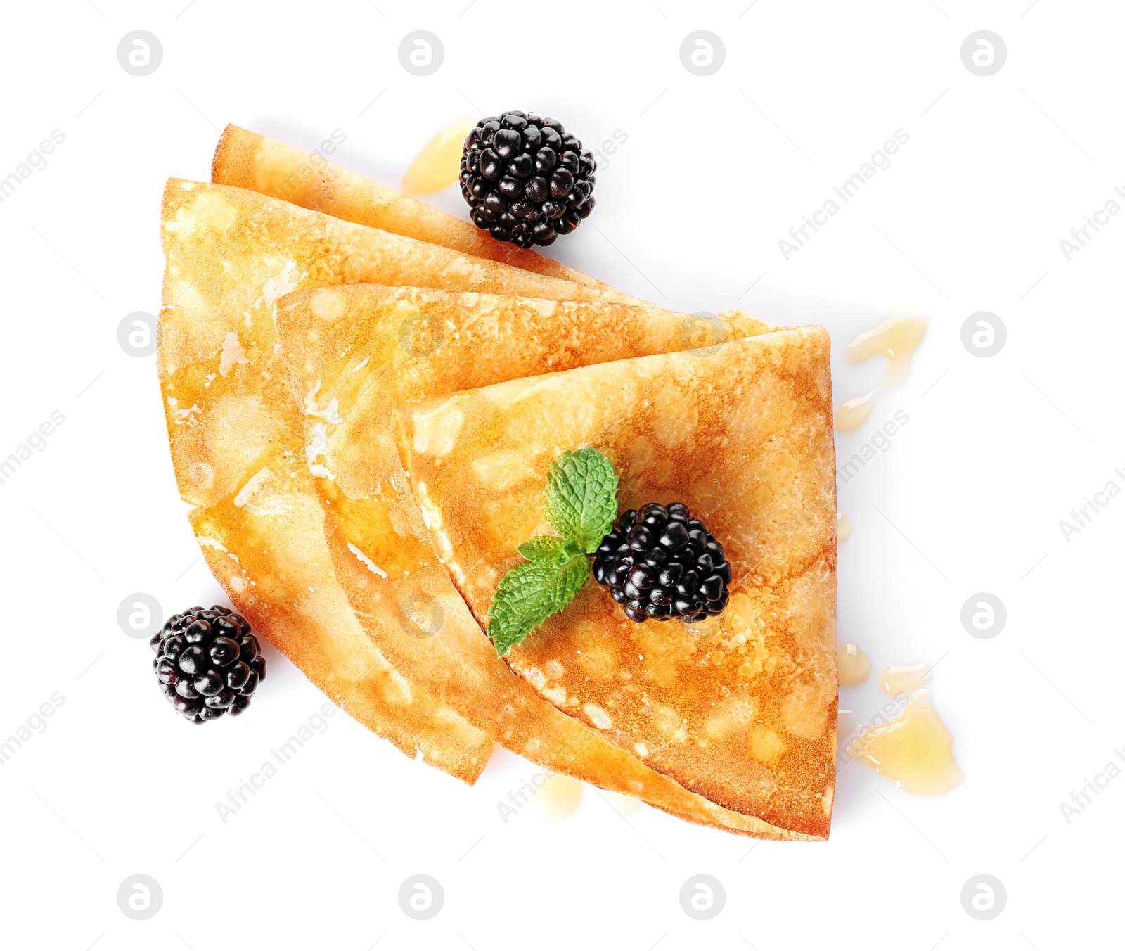 Photo of Tasty thin pancakes with maple syrup and berries on white background, top view