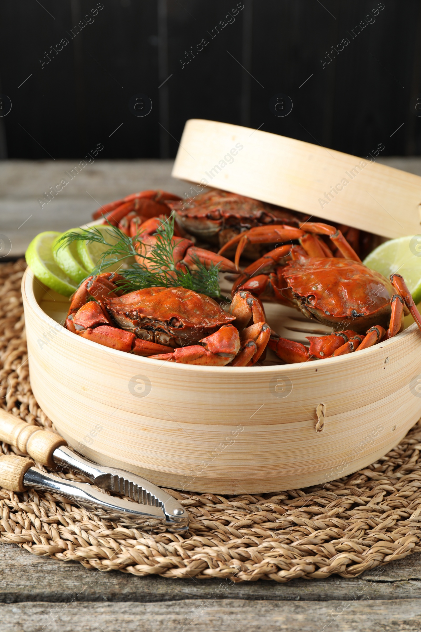 Photo of Delicious boiled crabs with lime and dill served on wooden table