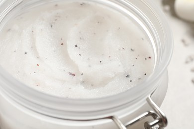 Body scrub in glass jar on table, closeup