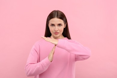 Photo of Woman showing time out gesture on pink background