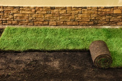 Photo of Laying grass sods at backyard. Home landscaping