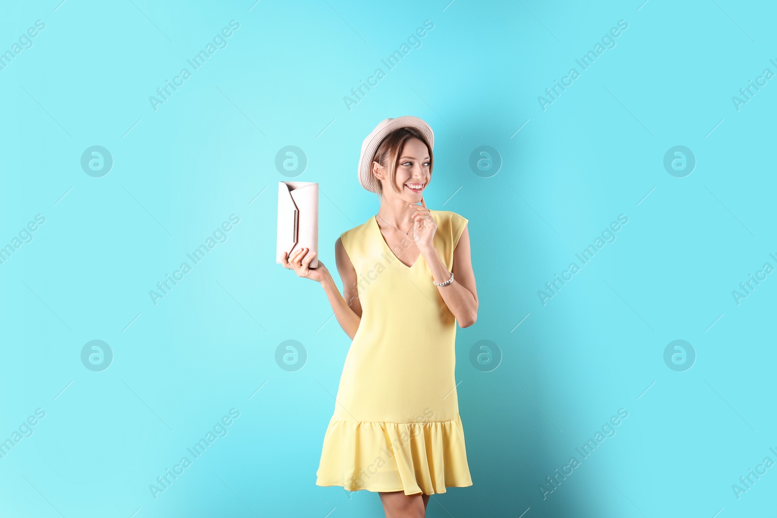 Photo of Portrait of young woman in stylish outfit with purse on color background