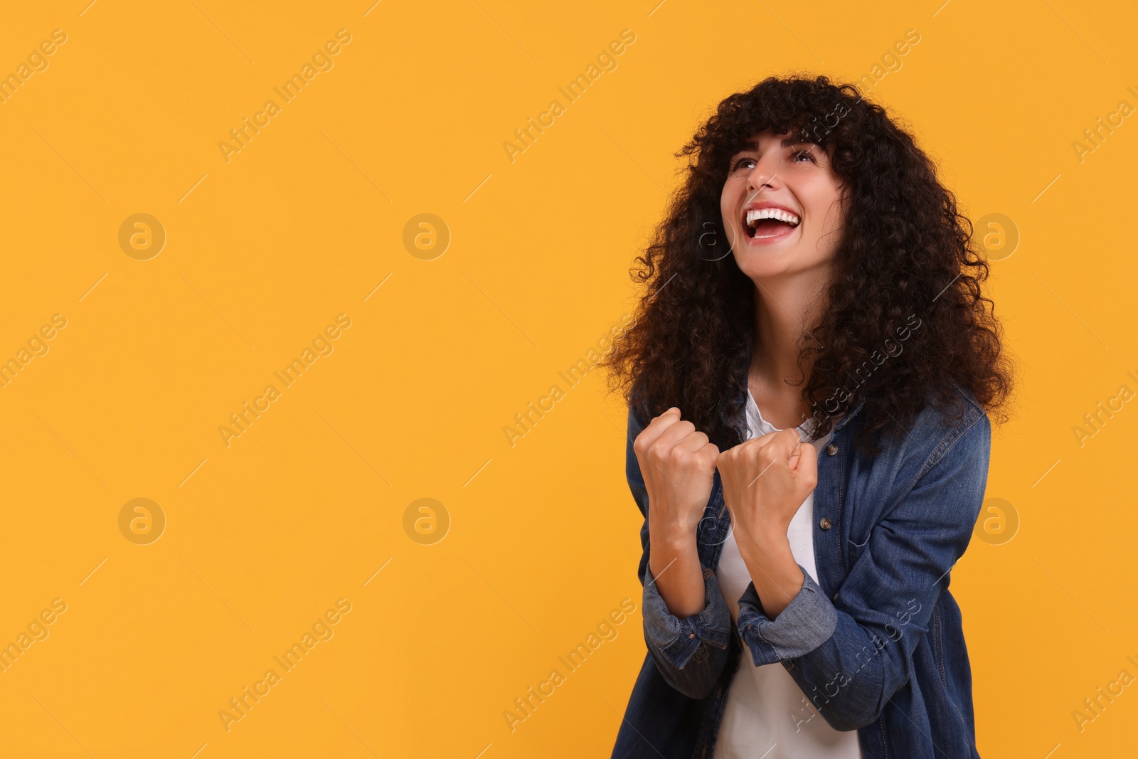 Photo of Happy sports fan celebrating on yellow background, space for text