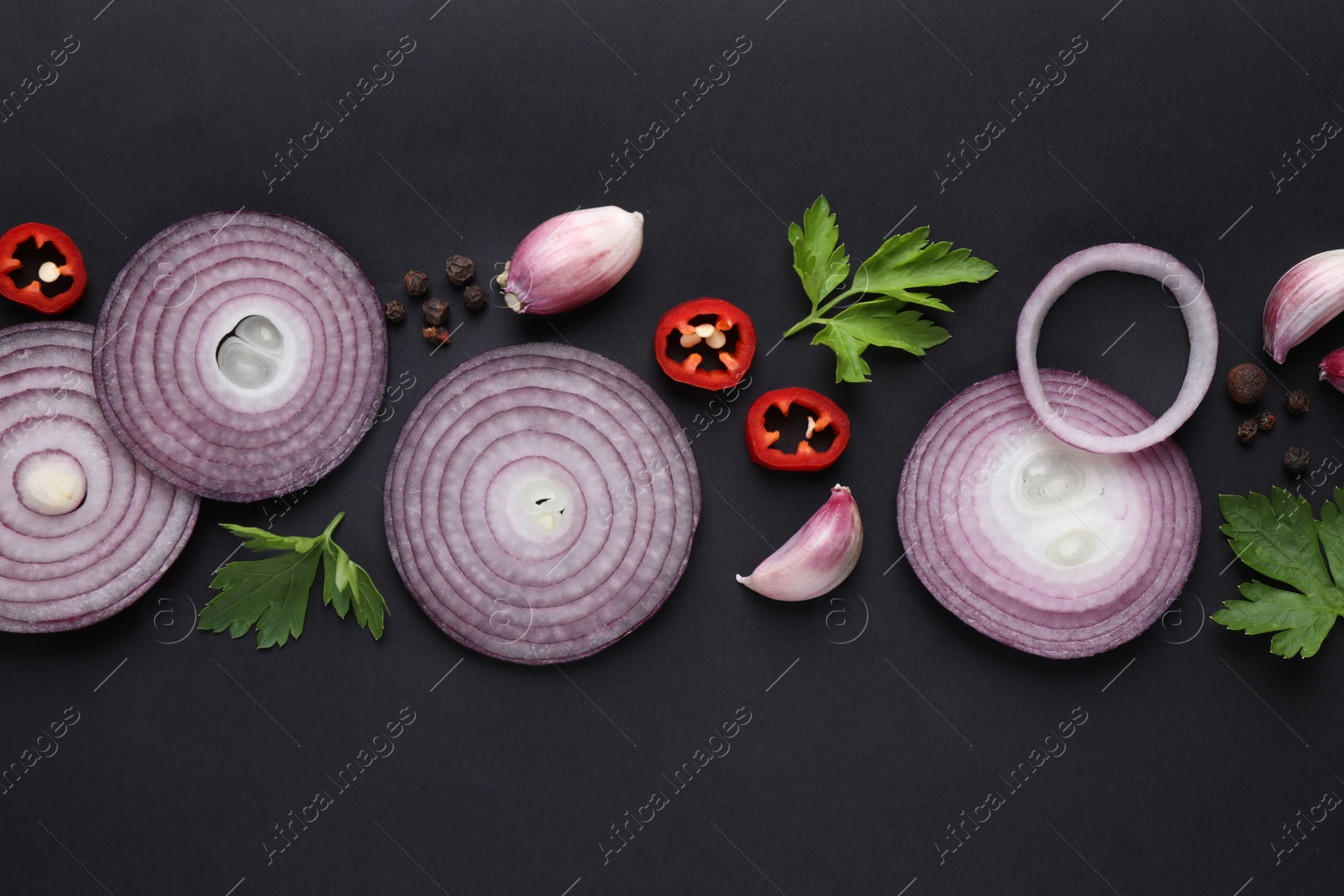Photo of Flat lay composition with slices of onion and spices on black background
