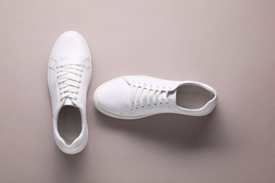 Photo of Pair of stylish white sneakers on grey background, top view