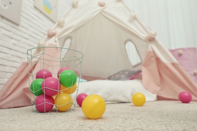 Photo of Bright balls near play tent in child's room. Interior design