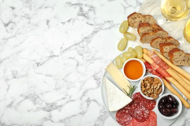 Photo of Flat lay composition with wine, snacks and space for text on marble background