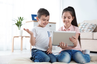 Photo of Little children using video chat on tablet at home