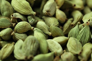 Photo of Dry green cardamom pods as background, closeup