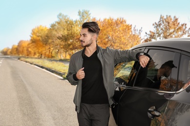 Young man near modern car on sunny day, outdoors